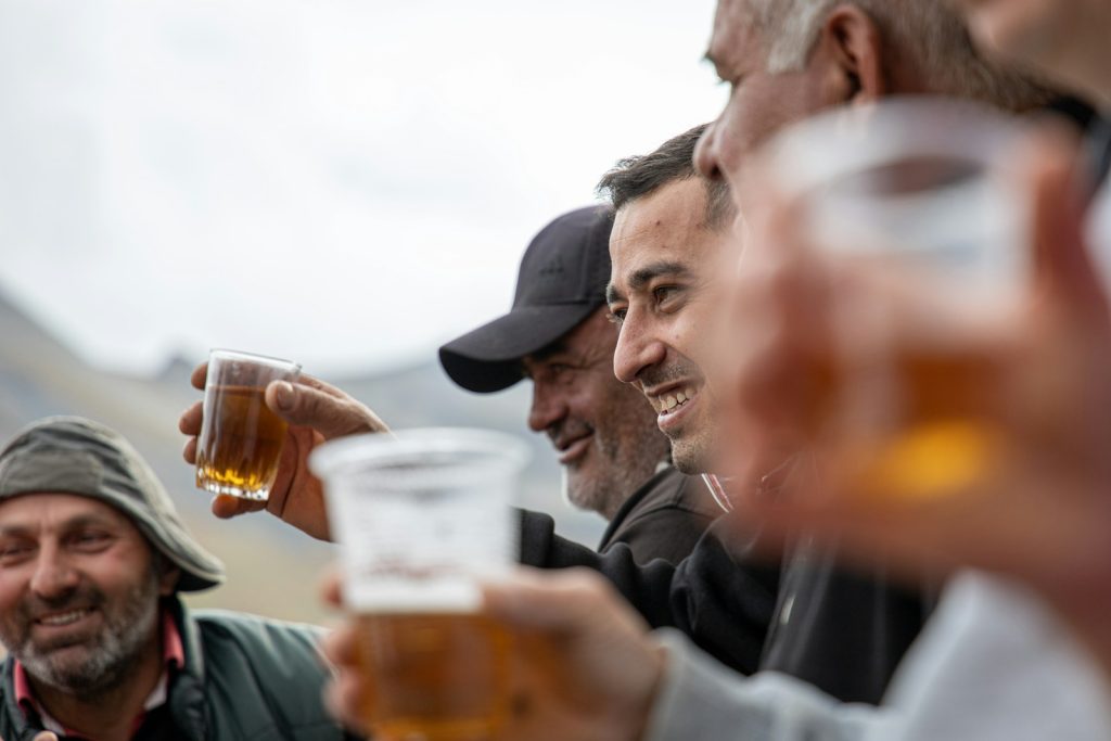 a group of men toasting and drinking beer